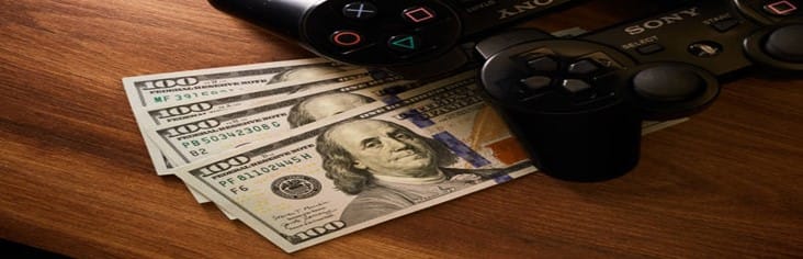 Learn-How-To-Make-Money-In-The-Gaming-Industry-A-Gamers-Guide-featured-image-200x620w-playstation-controllers-with-100-dollar-bills-on-wooden-surface-make-xtra-money-online